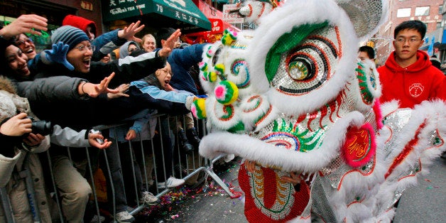 FILE- In this Sunday, Feb. 10, 2008 file photo, spectators try to attract the attention of a dragon figure during the Chinatown Lunar New Year parade in New York. You don't have to be in Asia to celebrate the arrival of the year of the dragon, Jan. 23. From New York City to Vancouver, there are parades, performances and other events in many North American cities. (AP Photo/Kathy Willens, file)