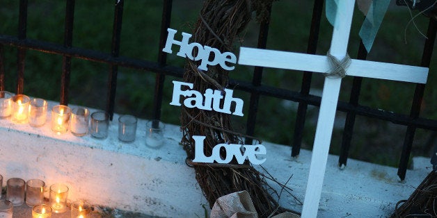 CHARLESTON, SC - JUNE 20: A cross sits among the memorial on the sidewalk in front the Emanuel African Methodist Episcopal Church after a mass shooting at the church killed nine people on June 20, 2015 in Charleston, United States. Dylann Roof, 21 years old, has been charged with killing nine people during a prayer meeting in the church, which is one of the nation's oldest black churches in Charleston. (Photo by Joe Raedle/Getty Images)