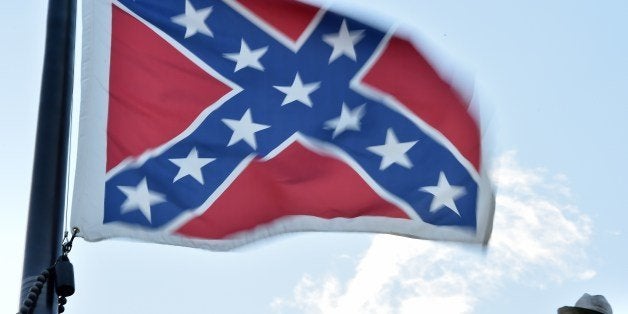 The Confederate flag is seen next to the monument of the victims of the Civil War in Columbia, South Carolina on June 20, 2015. The racially divisive Confederate battle flag flew at full-mast despite others flying at half-staff in South Carolina after the killing of nine black people in an historic African-American church in Charleston on June 17. Dylann Roof, the 21-year-old white male suspected of carrying out the Emanuel African Episcopal Methodist Church bloodbath, was one of many southern Americans who identified with the 13-star saltire in red, white and blue. AFP PHOTO/MLADEN ANTONOV (Photo credit should read MLADEN ANTONOV/AFP/Getty Images)