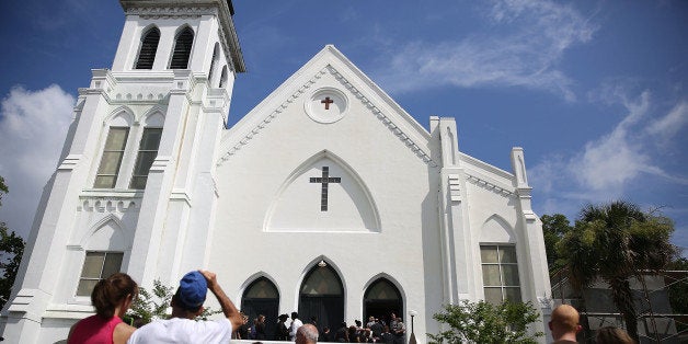 CHARLESTON, SC - JUNE 27: People look on as mourners file into the funeral of Cynthia Hurd, 54, at the Emanuel African Methodist Episcopal Church where she was killed along with eight others in a mass shooting at the church on June 27, 2015 in Charleston, South Carolina. Suspected shooter Dylann Roof, 21 years old, is accused of killing nine people on June 17th during a prayer meeting in the church, which is one of the nation's oldest black churches in Charleston. (Photo by Joe Raedle/Getty Images)