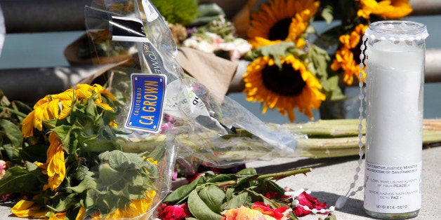 Flowers and a candle lay on the ground following a vigil for Kathryn Steinle, Monday, July 6, 2015, on Pier 14 in San Francisco. Steinle was gunned down while out for an evening stroll at Pier 14 with her father and a family friend on Wednesday, July 1. (AP Photo/Beck Diefenbach)