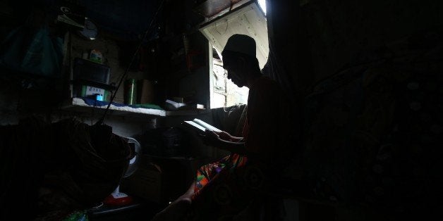 In this July 9, 2015, photo, Filipino Muslim Munib Dalidig reads the Koran inside his home in suburban Tumana, Marikina city, east of Manila, Philippines. Dalidig, who earns a living by selling DVDs on his pedicab, is among the Muslim minority in the Philippines, whose population is predominantly Roman Catholic. (AP Photo/Aaron Favila)