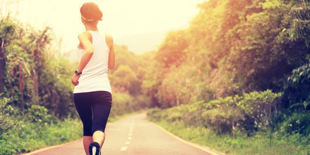 young fitness woman runner running at forest trail