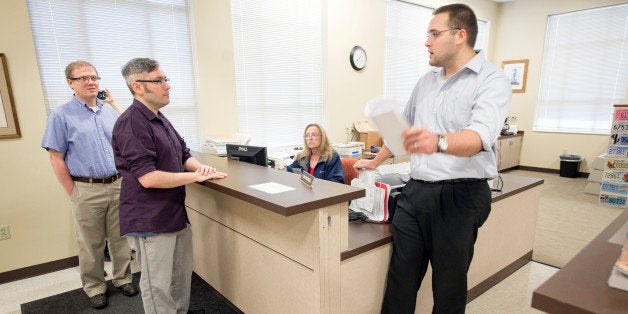 Rowan County Deputy Clerk Nathan Davis, right, informs David Moore, center, and David Ermold, left, that he won't issue them a marriage license Thursday, August 13, 2015 at the Rowan County Clerk's office in Morehead, Ky. Moore and Ermold were at the courthouse early Thursday following an order by a federal judge that Rowan County Clerk Kim Davis issue the licenses, despite her religious convictions. (John Flavell/Lexington Herald-Leader/TNS via Getty Images)