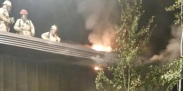 In this image made from a video provided by KREM.com, firefighters try to put out a fire at a Planned Parenthood clinic in Pu