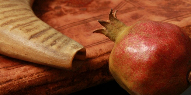 Atmospheric image of Judaism symbols of Rosh Hashana, The Jewish New Year. A Prayer Book, Shophar (Shofar) and Pomegranate