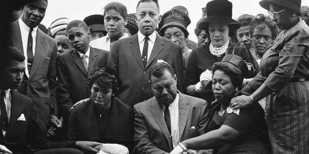 The family of Carol Robertson, a 14-year-old African American girl killed in a church bombing, attend graveside services for her, Sept. 17, 1963, Birmingham, Ala. Seated left to right: Carol Robertsons sister Dianne and parents, Mr. Alvin Robertson Sr. and Mrs. Alpha Robertson. The others are unidentified. (AP Photo/Horace Cort)