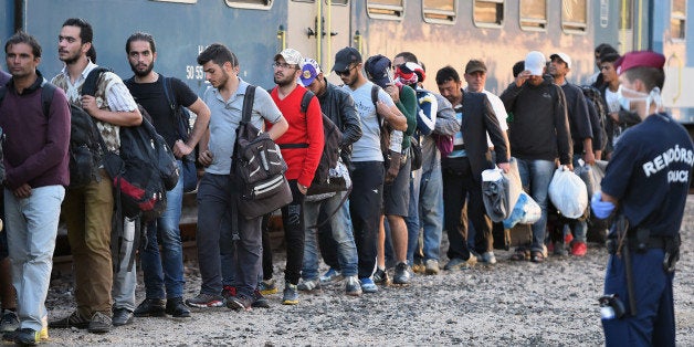 MAGYARBOLY, HUNGARY - SEPTEMBER 22: Migrants board a train at Magyarboly station heading for Austria on September 22, 2015,