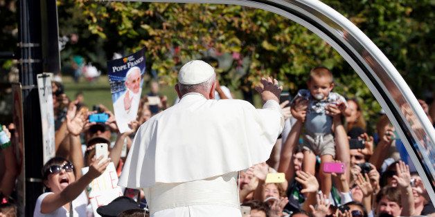 Pope Francis waves to the crowd from the popemobile during a parade in Washington, Wednesday, Sept. 23, 2015, following a state arrival ceremony hosted by President Barack Obama at the White House. (AP Photo/Alex Brandon, Pool)