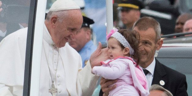Pope Francis touches a toddler after kissing her at a stop in Logan Square on the Benjamin Franklin Parkway in Philadelphia on Sunday, Sept. 27, 2015. (Clem Murray/Philadelphia Inquirer/TNS via Getty Images)