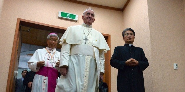 Pope Francis (C) arrives for a meeting with Catholic bishops from 22 Asian countries at a martyrs' shrine in Haemi, some 150 kilometres south of Seoul on August 17, 2014, on the penultimate day of a visit to South Korea. Pope Francis on August 17 championed a 'creative' Catholicism in Asia that reflects the region's diversity, and urged countries like China and North Korea to respond by fostering a proper dialogue with the Vatican. AFP PHOTO / VINCENZO PINTO (Photo credit should read VINCENZO PINTO/AFP/Getty Images)