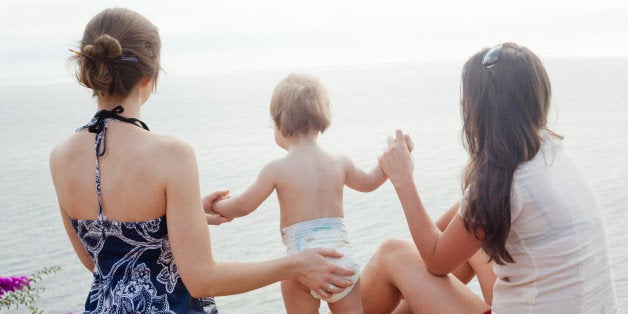 women holding baby's hand