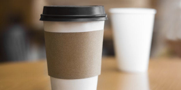 Two paper coffee cups on wooden table