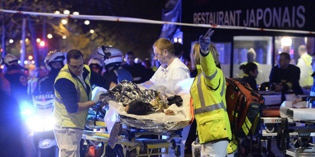 Rescuers evacuate an injured person near the Bataclan concert hall in central Paris, early on November 14, 2015. At least 120 people were killed in a series of terror attacks in Paris on November 13 according to a provisional total, a source close to the investigation said. AFP PHOTO / MIGUEL MEDINA (Photo credit should read MIGUEL MEDINA/AFP/Getty Images)