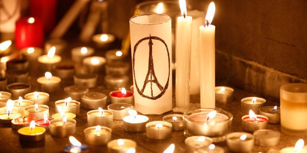 Candles are lit as people gather in Hong Kong, Saturday, Nov. 14, 2015, to mourn for the victims killed in Friday's attacks i