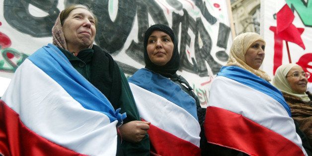 PARIS - JANUARY 17: Muslim women demonstrate against the French proposal to bar Muslim women from wearing headscarves in state schools on January 17, 2004 in Paris, France. French President Jacques Chirac asked parliament to ban the wearing of 'hijab' (head scarf in Arabic). Other conspicuous religious symbols such as Jewish skullcaps and large crosses also face a ban in public schools to protect the country's secular nature. (Photo by Pascal Le Segretain/Getty Images) 