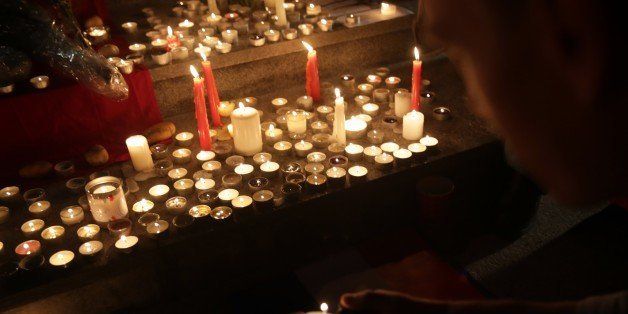 A man lights a candle at a vigil in Tamar Park for the victims of the Paris terror attacks in Hong Kong on November 16, 2015. People around the world express their solidarity with France following a spate of coordinated attacks that left 128 dead and 180 injured in Paris late on November 13. AFP PHOTO / ISAAC LAWRENCE (Photo credit should read Isaac Lawrence/AFP/Getty Images)