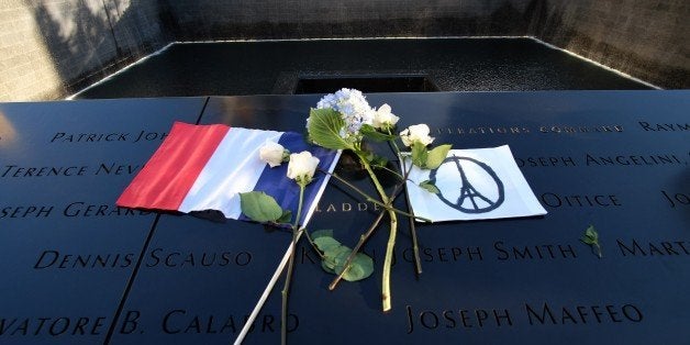 A French flag, flowers and a 'Peace for Paris' drawing are seen at the 9/11 memorial in New York on November 16, 2015, during