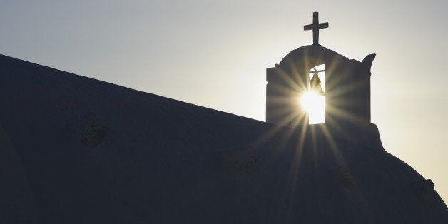 Greece, Sun shines through belltower in Oia village at Santorini