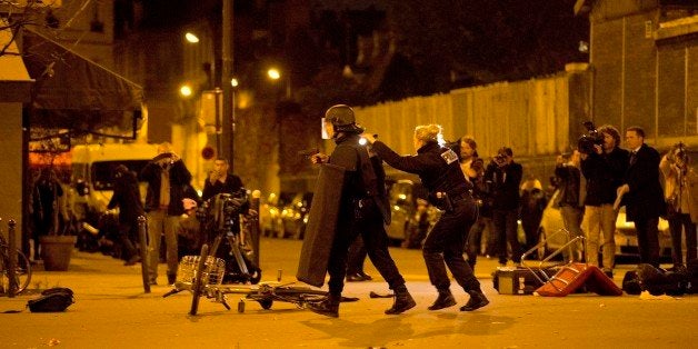 French police secure the perimeter after panic broke out among mourners who payed their respect at the attack sites at restaurant Le Petit Cambodge (Little Cambodia) and the Carillon Hotel in Paris, Sunday, Nov. 15, 2015. Thousands of French troops deployed around Paris on Sunday and tourist sites stood shuttered in one of the most visited cities on Earth while investigators questioned the relatives of a suspected suicide bomber involved in the country's deadliest violence since World War II. (AP Photo/Peter Dejong)