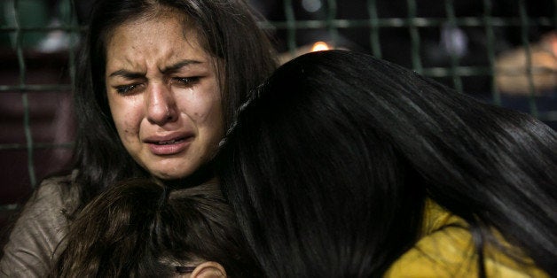 SAN BERNARDINO, CA - DECEMBER 3: Faith Rodriguez, 15, embrace family members during an emotional candlelight vigil to honor the victims of the mass shootings at the Inland Regional Center December 3, 2015 at San Manuel Stadium in San Bernardino, California. Investigators are looking for a motive as to why Syed Rizwan Farook and Tashfeen Malik went on a shooting rampage that left 14 dead and at least 17 others wounded. (Photo by Marcus Yam/Los Angeles Times via Getty Images)