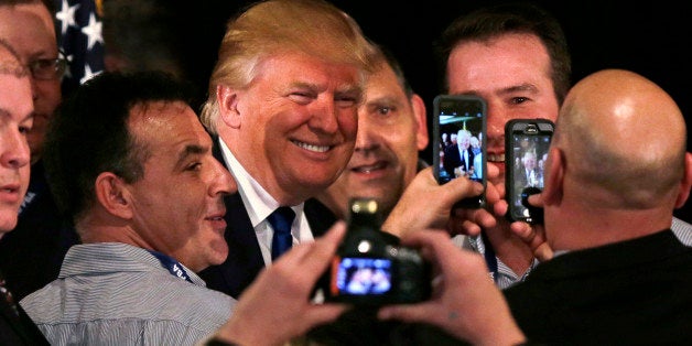 Republican presidential candidate, businessman Donald Trump smiles as he has his photograph taken with supporters after being
