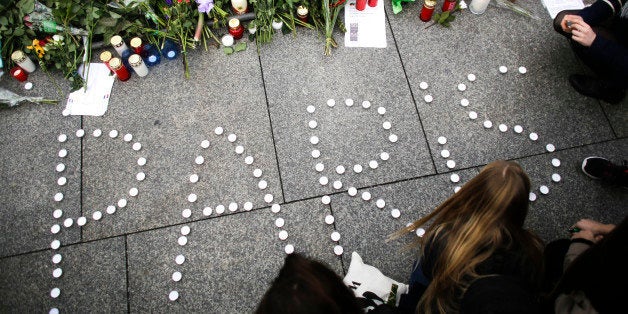FILE - In this Saturday, Nov. 14, 2015 file photo, young women have formed the word Paris with candles to mourn for the vict