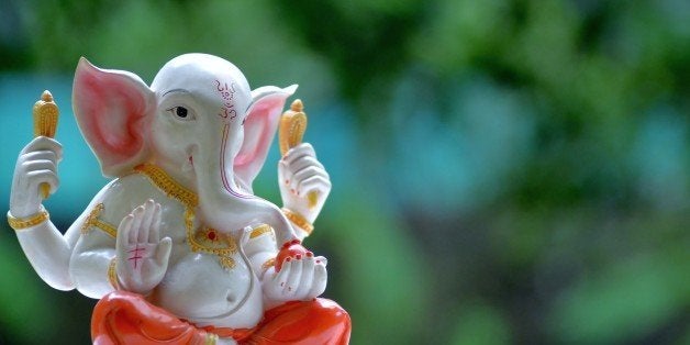 Hindu God,Lord Ganesha against green background.