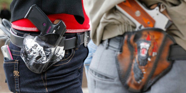 AUSTIN, TX - JANUARY 1: Art and Diana Ramirez of Austin with their pistols in custom-made holsters during and open carry rally at the Texas State Capitol on January 1, 2016 in Austin, Texas. On January 1, 2016, the open carry law takes effect in Texas, and 2nd Amendment activists hold an open carry rally. (Photo by Erich Schlegel/Getty Images)