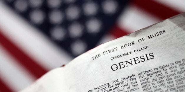 'XXXL photo of a bible open to the first page of Genesis with selective focus in the foreground and a blurred American flag in the background, can illustrate many concepts such as church and state, religion in politics, creationism in America, conservative right in America, etc.'