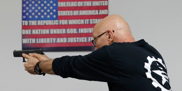 Mike Weinstein, director of training and security at the National Armory gun store and gun range, shows how to safely fire a