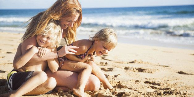Mother with son (6-7) and daughter (2-3) on beach