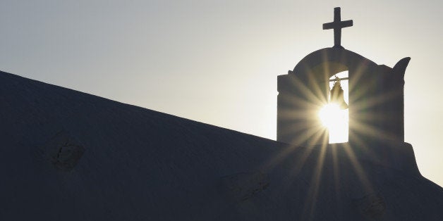 Greece, Sun shines through belltower in Oia village at Santorini