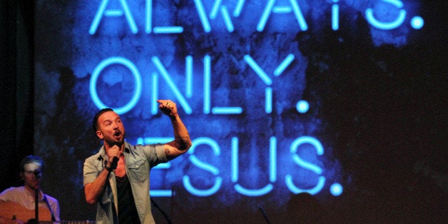 In this July 14, 2013 photo, Pastor Carl Lentz, foreground, leads a Hillsong NYC Church service at Irving Plaza in New York.