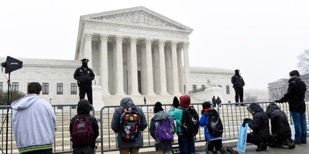 People kneel outside the Supreme Court in Washington, Friday, Jan. 22, 2016, during the March for Life 2016, the annual rally held on the anniversary of 1973 'Roe v. Wade' U.S. Supreme Court decision legalizing abortion. (AP Photo/Susan Walsh)