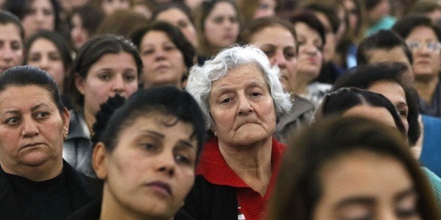 Iraqi Christians, who fled the violence in the northern city of Mosul after Islamic State (IS) group militants took control of the area, attend a Christmas eve mass at the Syriac Catholic church in the Ashti camp in Arbil, the capital of the autonomous Kurdish region of northern Iraq, on December 24, 2015. AFP PHOTO / SAFIN HAMED / AFP / SAFIN HAMED (Photo credit should read SAFIN HAMED/AFP/Getty Images)