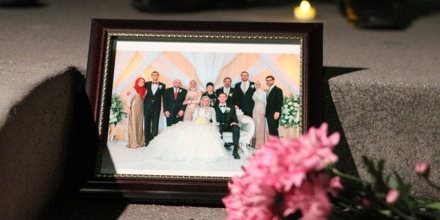 WASHINGTON, UNITED STATES - FEBRUARY 12: A picture of slain Muslim students who were shot dead in Chapel Hill, is seen at a m