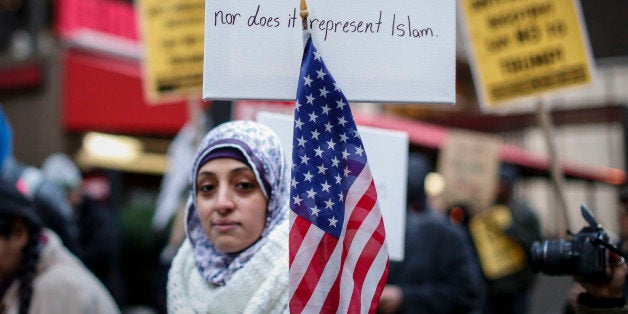 A Muslim woman holds a poster during a protest against Donald Trump on December 20, 2015 in New York. Republican presidentia