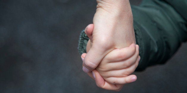 Child holding mother's hand.