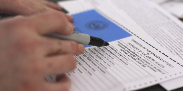 A voter prepares to mark an absentee presidential primary ballot for Bernie Sanders in New Hampshire.