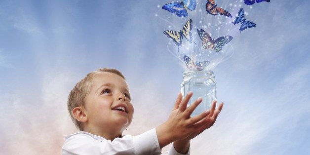 Boy releasing butterflies into the air concept for freedom, peace and spirituality