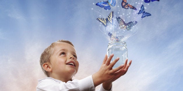 Boy releasing butterflies into the air concept for freedom, peace and spirituality