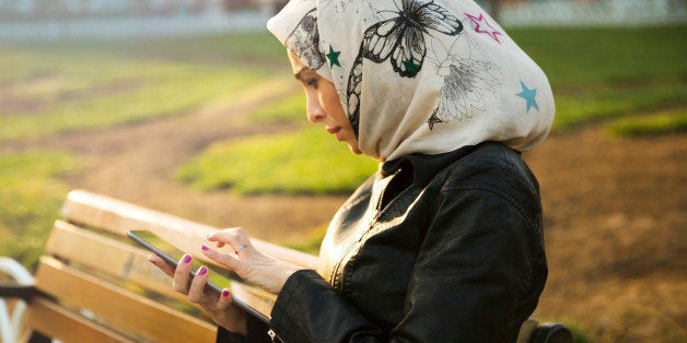 Woman reading on tablet in a city park. Istanbul, Turkey.