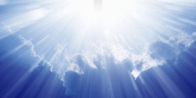 Jesus Christ in blue sky with clouds, bright light from heaven, resurrection, easter