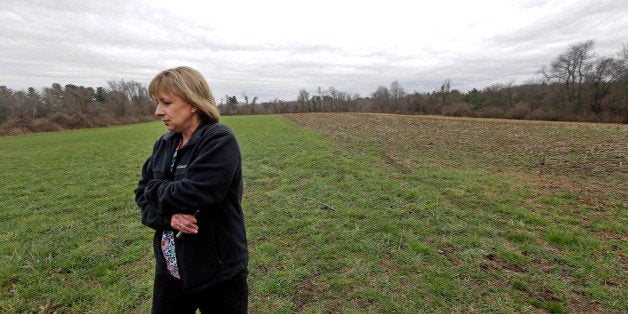 In this April 12, 2016 photo, Desiree Moninski, walks on land located across from her house in Dudley, Mass., which is the site of a proposed Muslim cemetery, a project vigorously opposed by area residents. Regarding the land once farmed by her grandparents, Moninski said she and other opponents have legitimate concerns that have nothing to do with Islam. "I grew up here. It's farmland, and I'd like to see it stay that way," she said. (AP Photo/Elise Amendola)