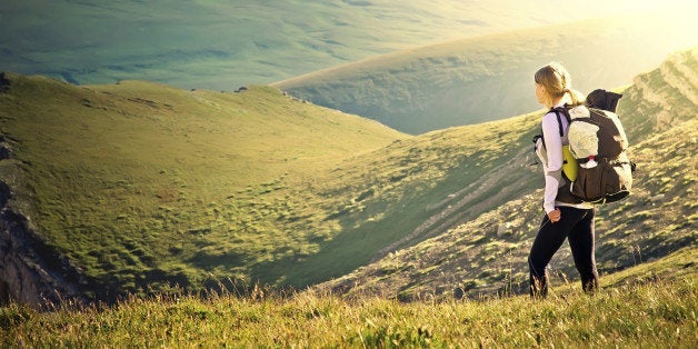 Woman Traveler with Backpack hiking in Mountains with beautiful summer landscape on background mountaineering sport lifestyle concept