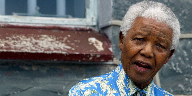 Nelson Mandela speaks to musicians beneath the window of his prisoncell on Robben Island near Cape Town, November 28, 2003. Mandelavisited the island with a host of stars who are to perform at the"46664" Aids benefit concert on November 29. "46664" refers to theprison number allocated to Mandela during his long incarceration on theIsland. REUTERS/Mike HutchingsMH/WS