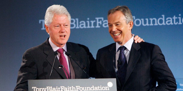 Former U.S. president Bill Clinton (L) introduces former British Prime Minister Tony Blair to the podium at the official lau