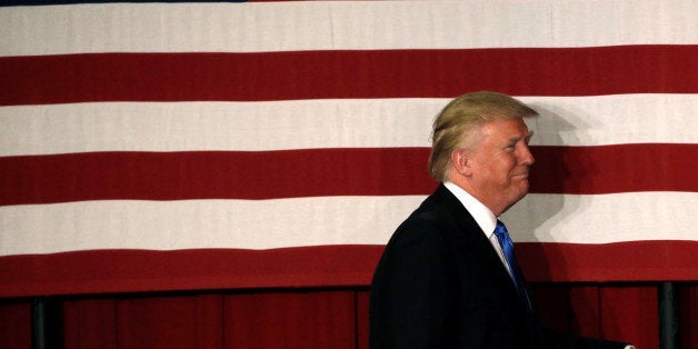 U.S. Republican presidential candidate Donald walks to the stage past an American flag at a fundraising event where he appeared with New Jersey Governor Chris Christie in Lawrenceville, New Jersey, U.S., May 19, 2016. REUTERS/Mike Segar