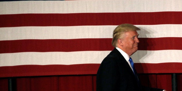 U.S. Republican presidential candidate Donald walks to the stage past an American flag at a fundraising event where he appeared with New Jersey Governor Chris Christie in Lawrenceville, New Jersey, U.S., May 19, 2016. REUTERS/Mike Segar